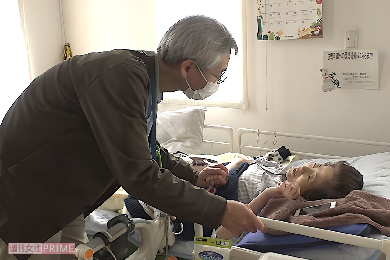  自宅で過ごす伊鈴さんのもとに診察に来た瀬角先生。帰り際には伊鈴さんの手をやさしく握り、伊鈴さんも笑顔で応える　写真／『家族のレシピ』（幻冬舎）より
