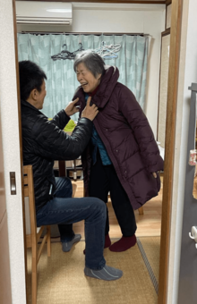 介護で母親に洋服を着せる山田