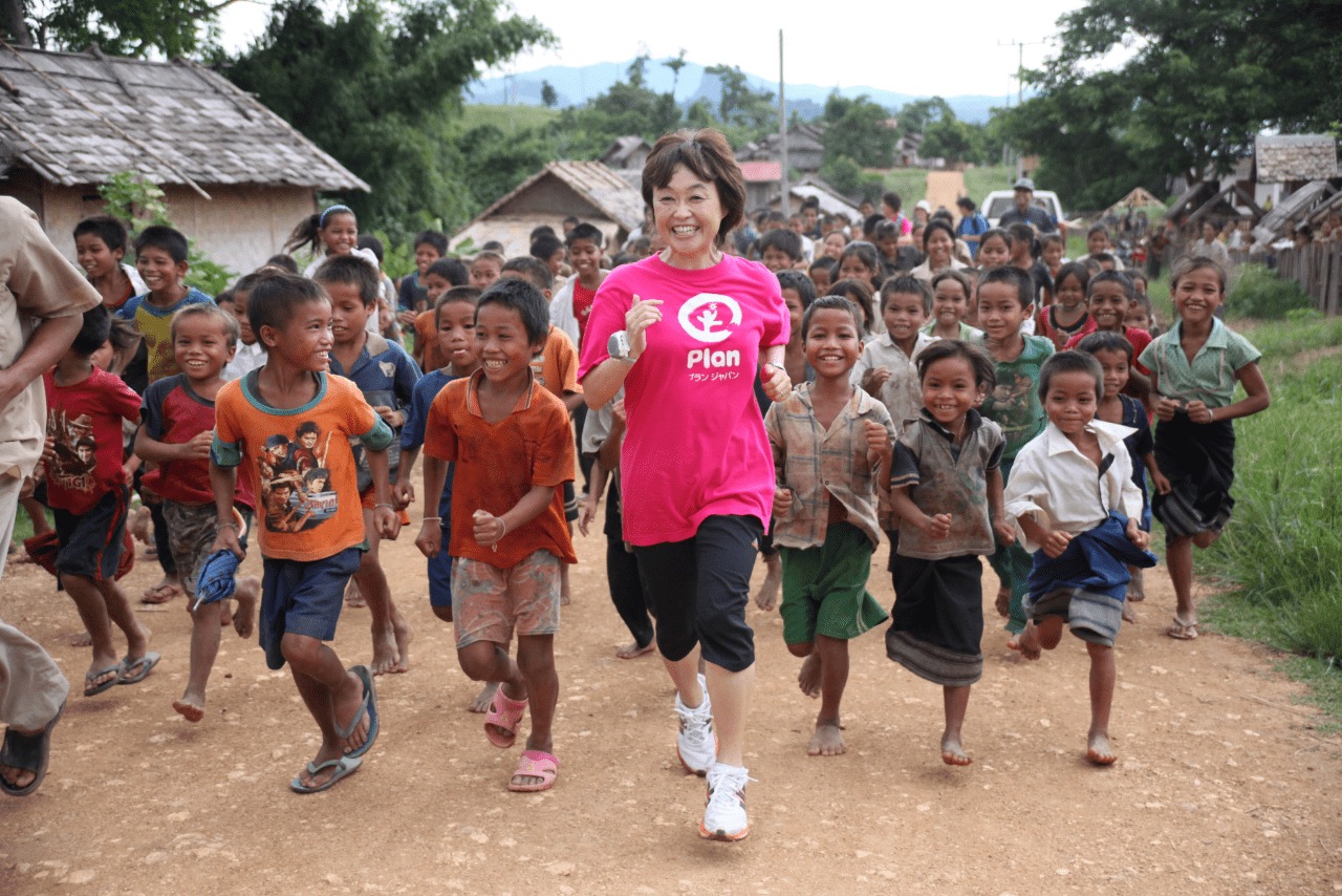 プランの活動でラオスを訪れたときのカット。子どもたちと一緒に走る増田も満面の笑み（提供：プラン・インターナショナル ジャパン　撮影：鬼室黎）