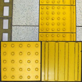 （写真上）ホーム端の警告ブロック＝駅ホームの白線の内側に設けられている。写真左手の白線の先に線路があり、ホーム中央寄りの警告ブロック右側に誘導ラインが1本入る。（写真左下）警告ブロック＝5×5の25点のドットで構成し、危険な場所などを示す。この先に階段があるときや改札口の手前、壁の手前などに置かれる。（写真右下）誘導ブロック＝4本の太いラインで構成し、進行方向を示す。ホーム、トイレ、改札口などへブロックを直線につなげて案内する