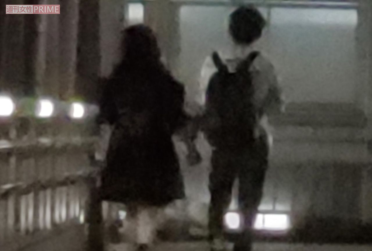 女性と手をつないで夜道を歩く小堀裕之