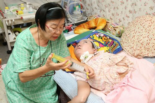 かのこさんは胃ろうで栄養剤や水分をとっている。以前、鼻から胃までチューブを入れていたときに比べると、格段に楽になった　撮影／齋藤周造