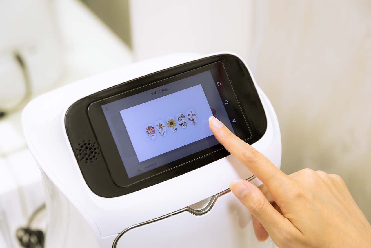 セルフネイルのマシンでデザインを選ぶ千春さん