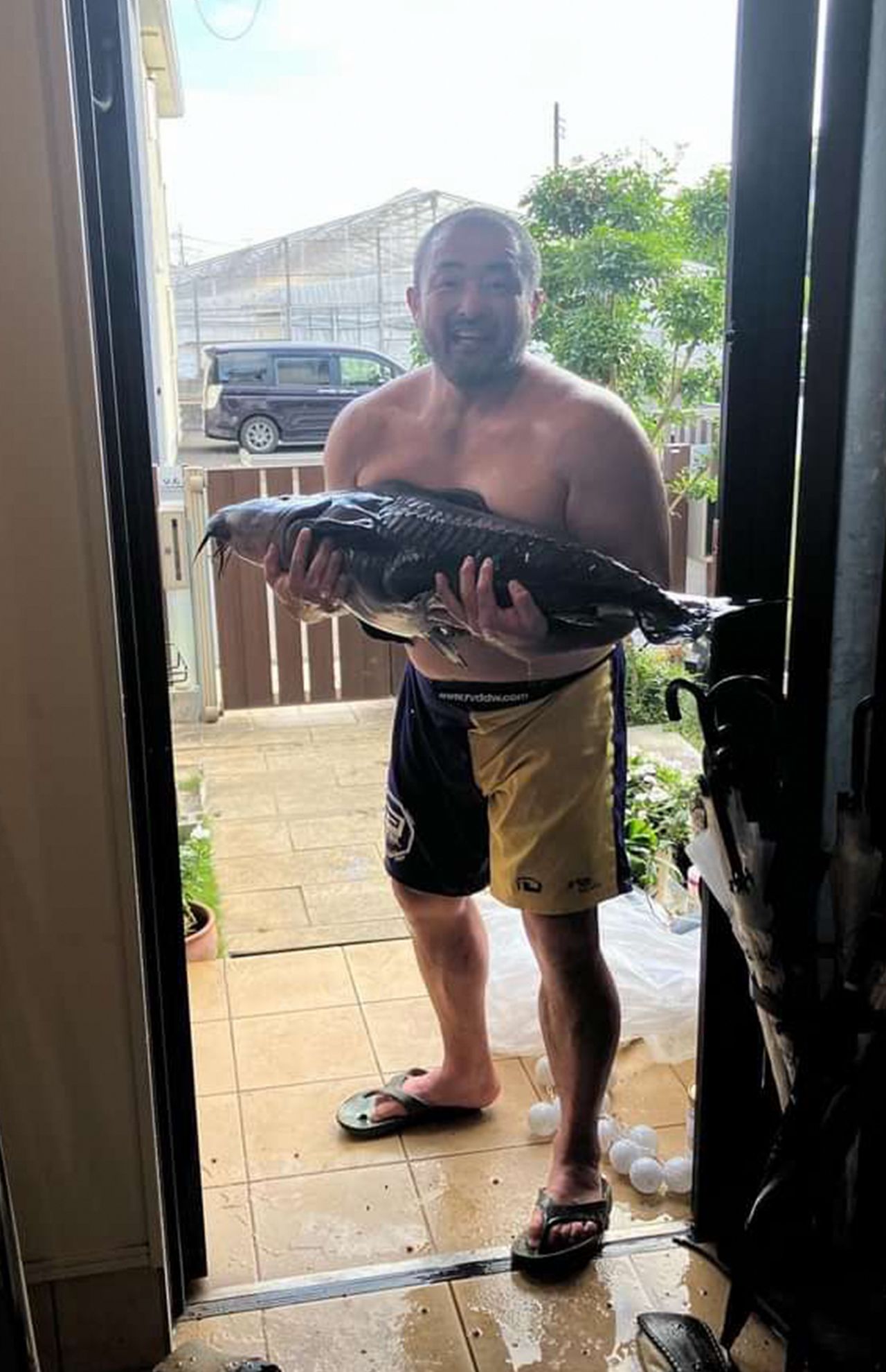 アマゾンの大型魚をプールに移す江口容疑者（本人のSNSより）