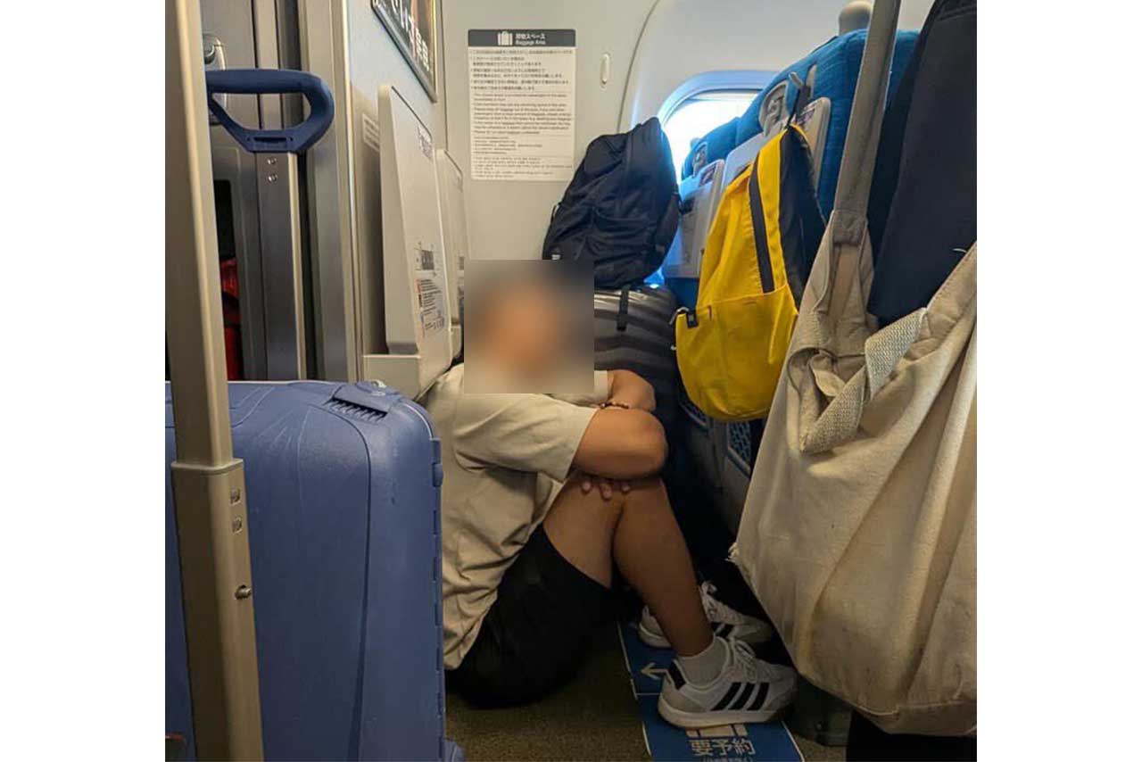 本来荷物を置くスペースのはずが…地べたで体育座りをする外国人旅行客とみられる男性（Xのユーザーより）