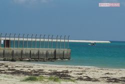 水平線に浮かぶ辺野古の埋め立て予定地の護岸の一部。手前は米軍基地のフェンス