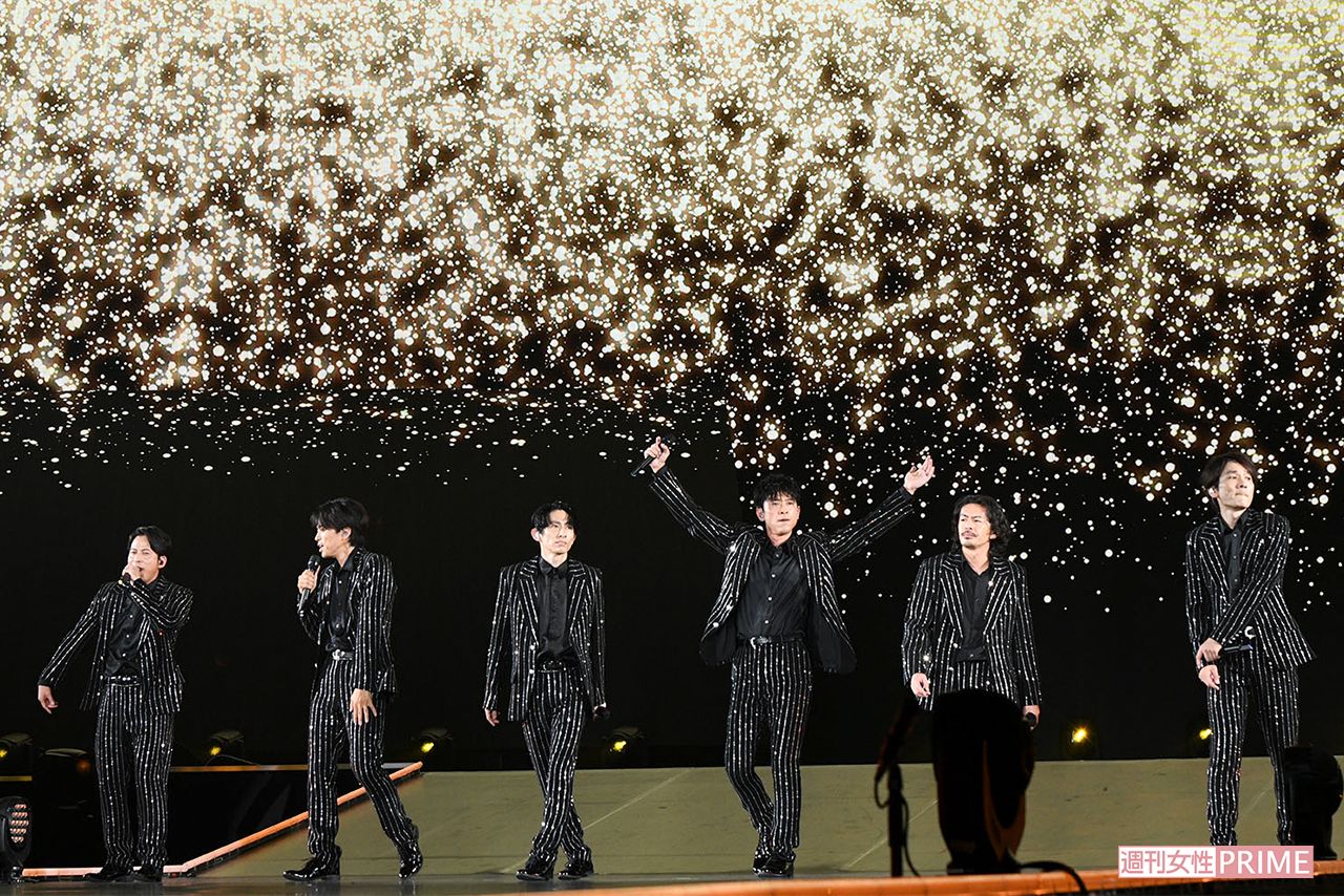 黒の衣装を纏い、華やかなステージで歌うV6のメンバー
