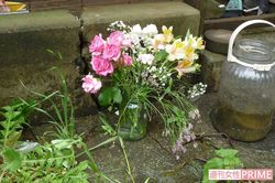 遺体が見つかった住居兼店舗には淡い色の花（切り込み）が手向けられていた