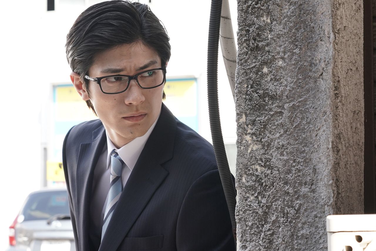 逃亡中の結城は、あるときはビジネスマンに変装　(c)フジテレビ