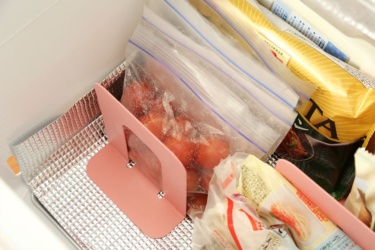【R】ブックエンドを使い立てて収納。保存袋はカゴに入れると、中身の増減でムダなスペースが生まれることがあるので、ブックエンドで仕切るのが◎。「より冷えが回る、金属製のものがいいですね！」