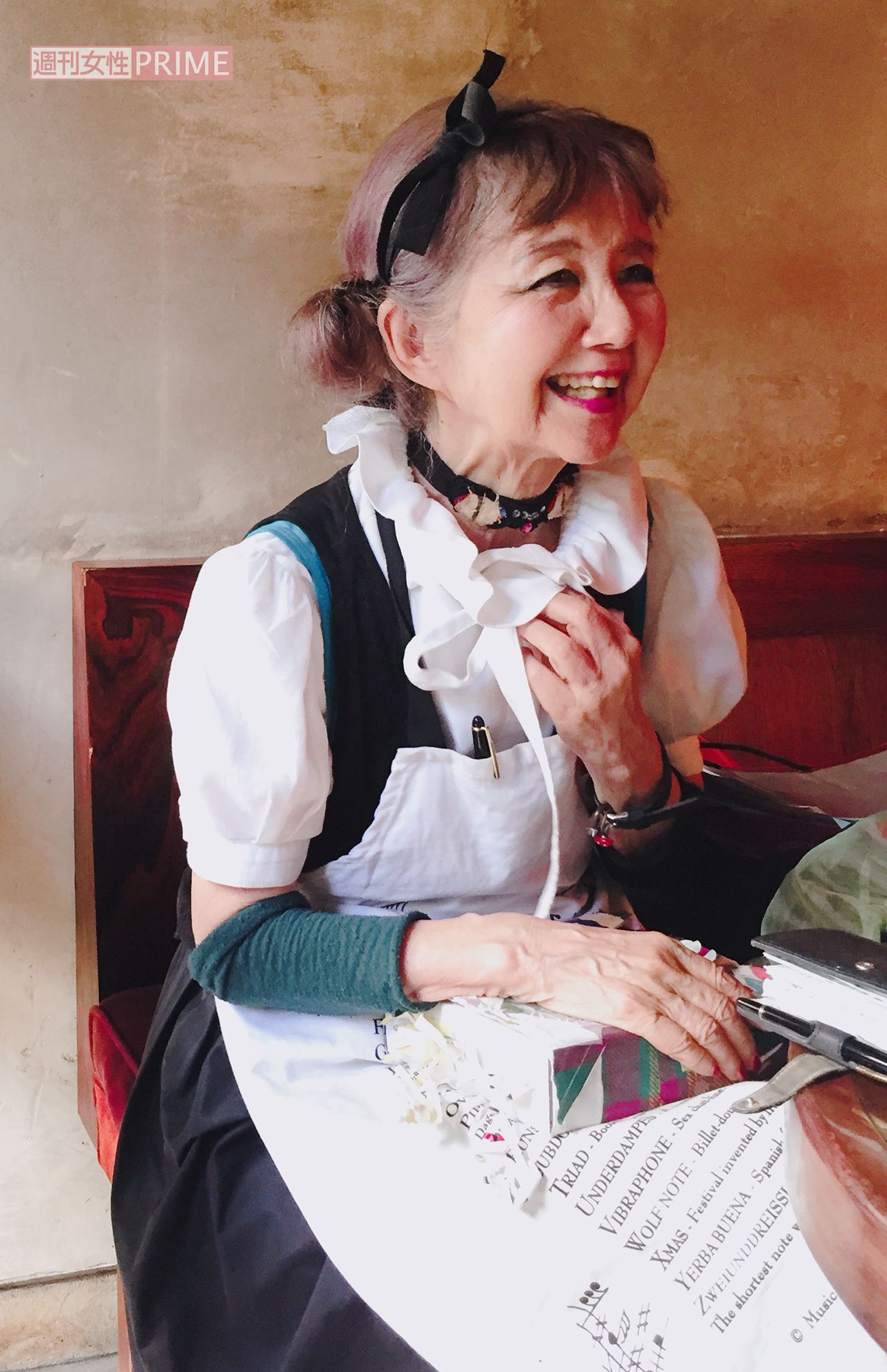 ご自身のイラストそっくりな田村さん。白いエプロンとお手製の黒猫チョーカーがお似合い