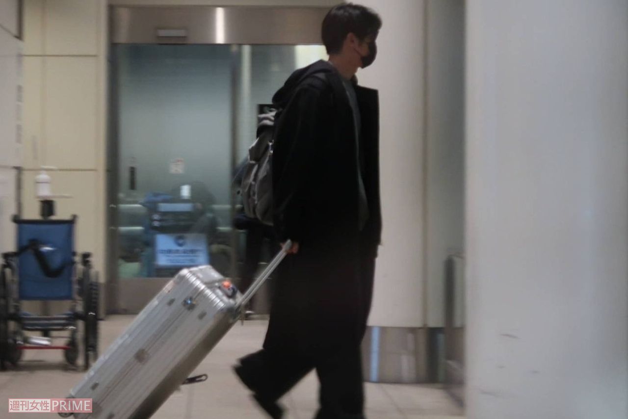 マスク姿の黄皓が到着ロビーにひとりで現れる。シルバーのスーツケースを運ぶ。