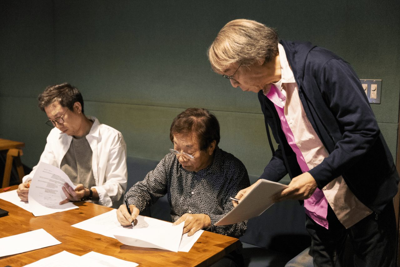 脚本家と原稿の修正を細かく相談する窪田等さん（撮影／矢島泰輔）