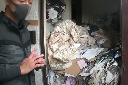石田さんが片付けた部屋の一例。玄関を開けると、胸の高さにまでゴミが積まれているのがわかる　写真／「ゴミ屋敷専門パートナーズ」YouTubeチャンネルより