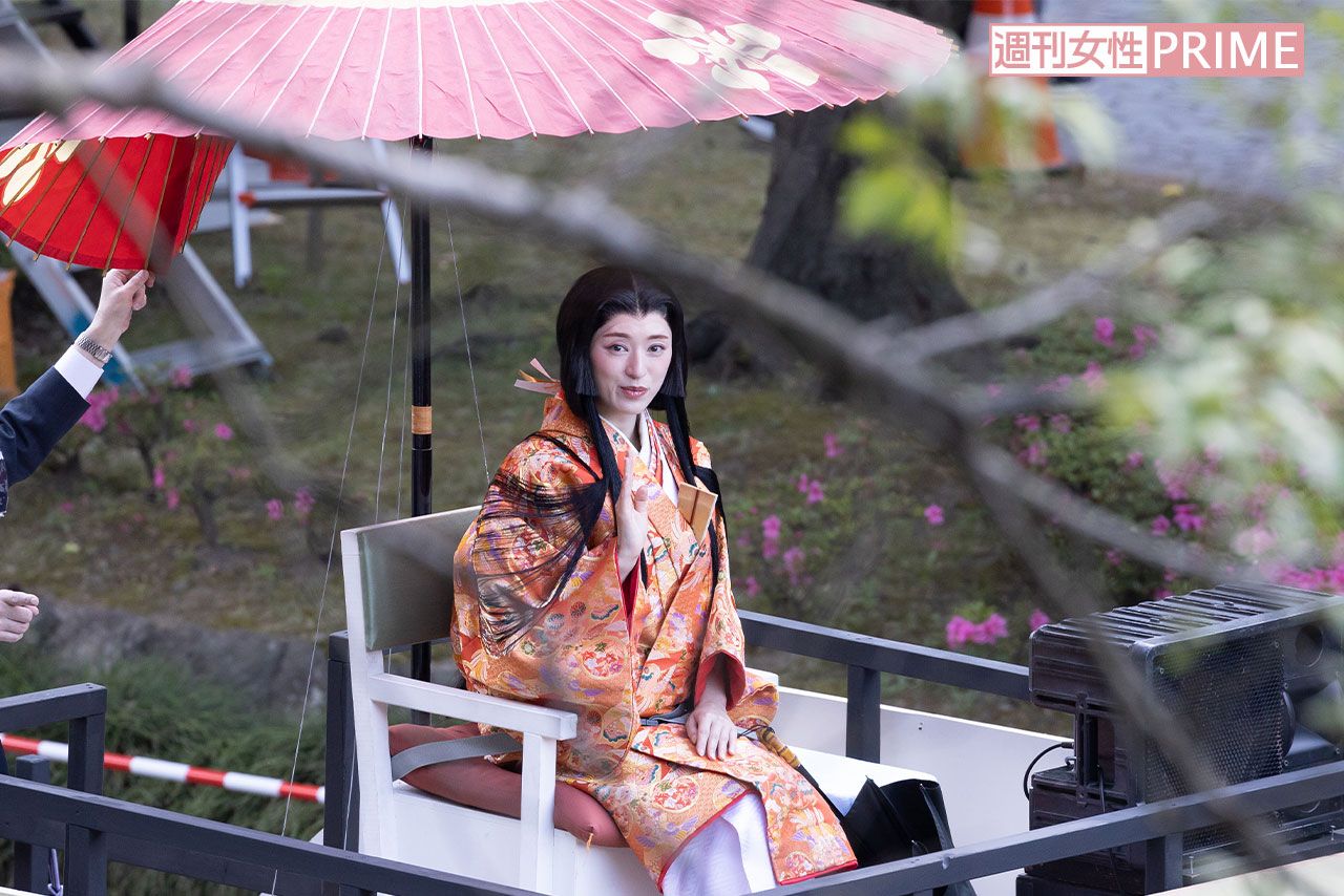 和傘に加え日傘をさして移動車に乗る栗山千明の周りには、撮影自粛を呼びかけるスタッフが