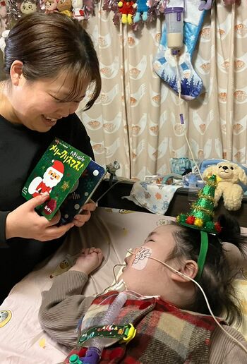 本退院後の5歳ごろのクリスマスパーティー。絵本を祖父からもらいご機嫌の様子の渡辺瑚々ちゃん