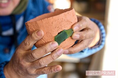 穴のあいた素焼きのわんにシーグラスを当て「失敗も工夫次第で化けるんだナ」と笑った　撮影／伊藤和幸