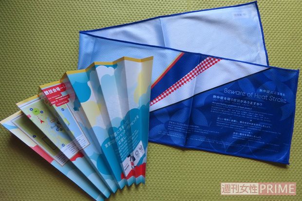 無料配布されていたぬらすと冷たくなるタオル（右）と、折り目をつけると扇子にもなる会場案内図