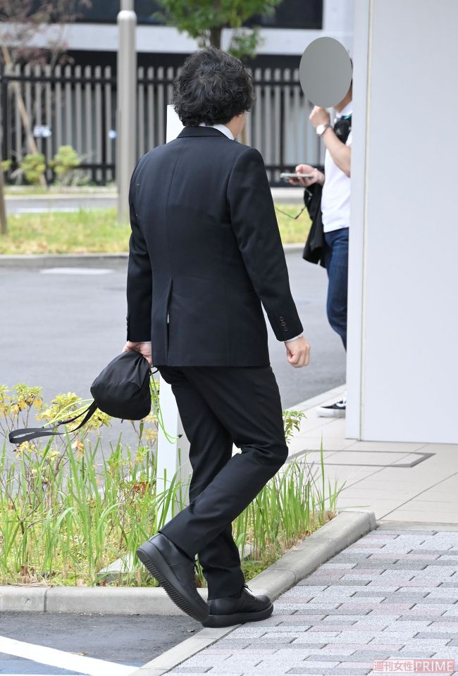 出廷した『flumpool』ギタリスト・阪井一生。手には黒の巾着袋のようなものが