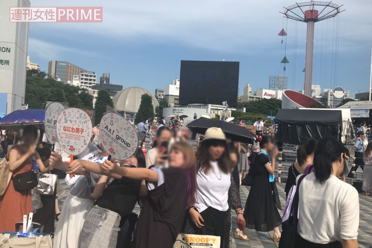 うちわを掲げて撮影するファン／著者撮影