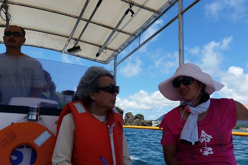 海上から工事中止を訴える抗議船の船長・相馬さん（右）と筆者。辺野古の埋め立て予定地にはサンゴ礁が広がる　撮影／浅井真由美