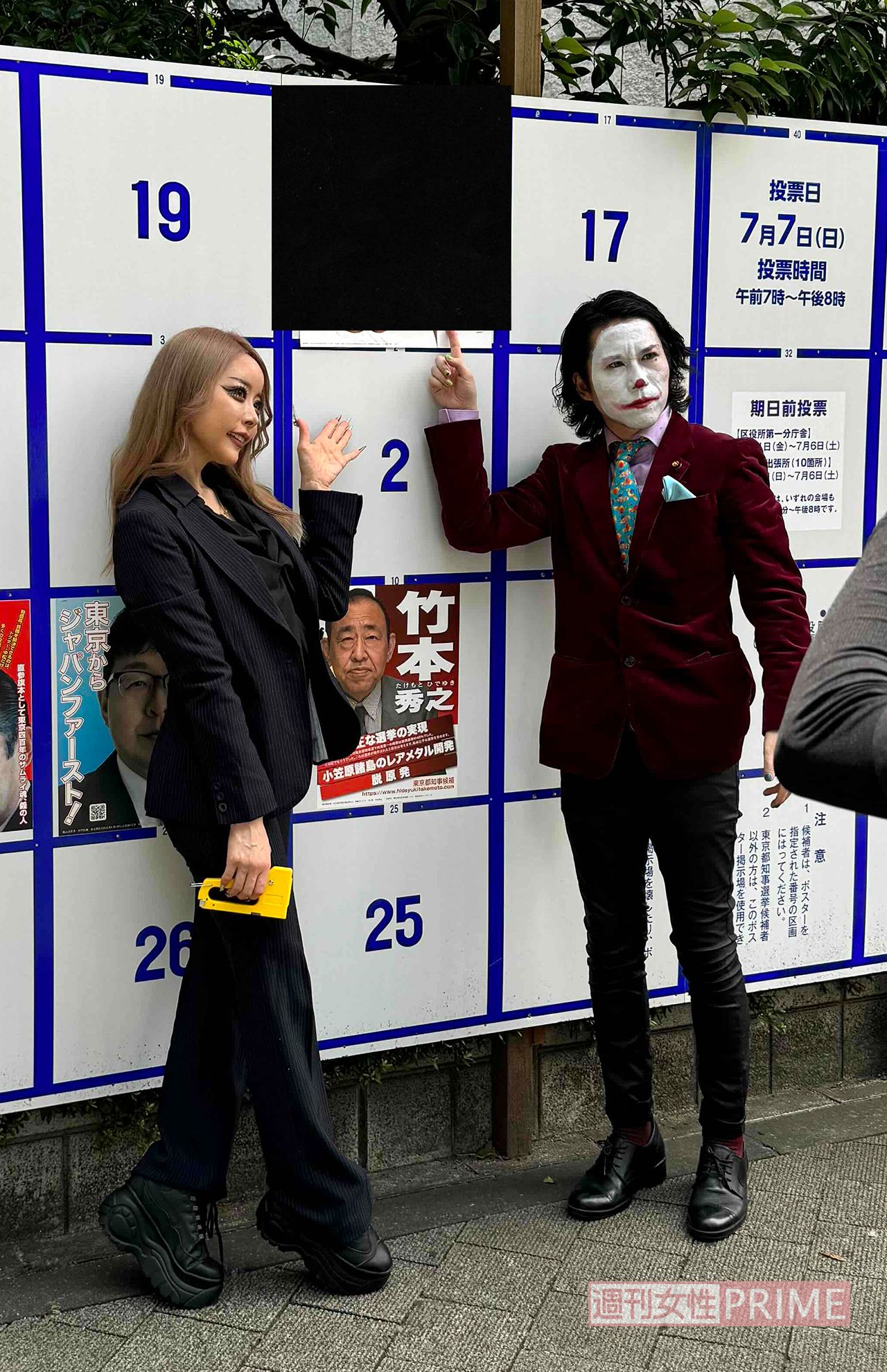 桜井MIU（左）の局部を河合氏（右）の顔で隠した選挙ポスターの前で記念撮影をする2人（画像は河合氏提供）＊ポスター部分は編集部で処理済み