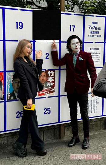 桜井MIU（左）の局部を河合氏（右）の顔で隠した選挙ポスターの前で記念撮影をする2人（画像は河合氏提供）＊ポスター部分は編集部で処理済み