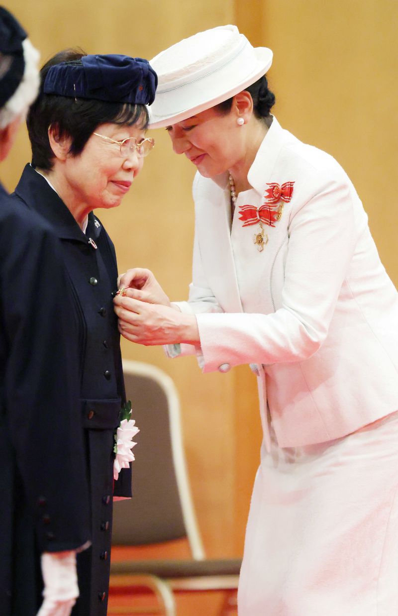 受章者の春山典子さんに、腰をかがめて記章を授ける雅子さま（7月31日）