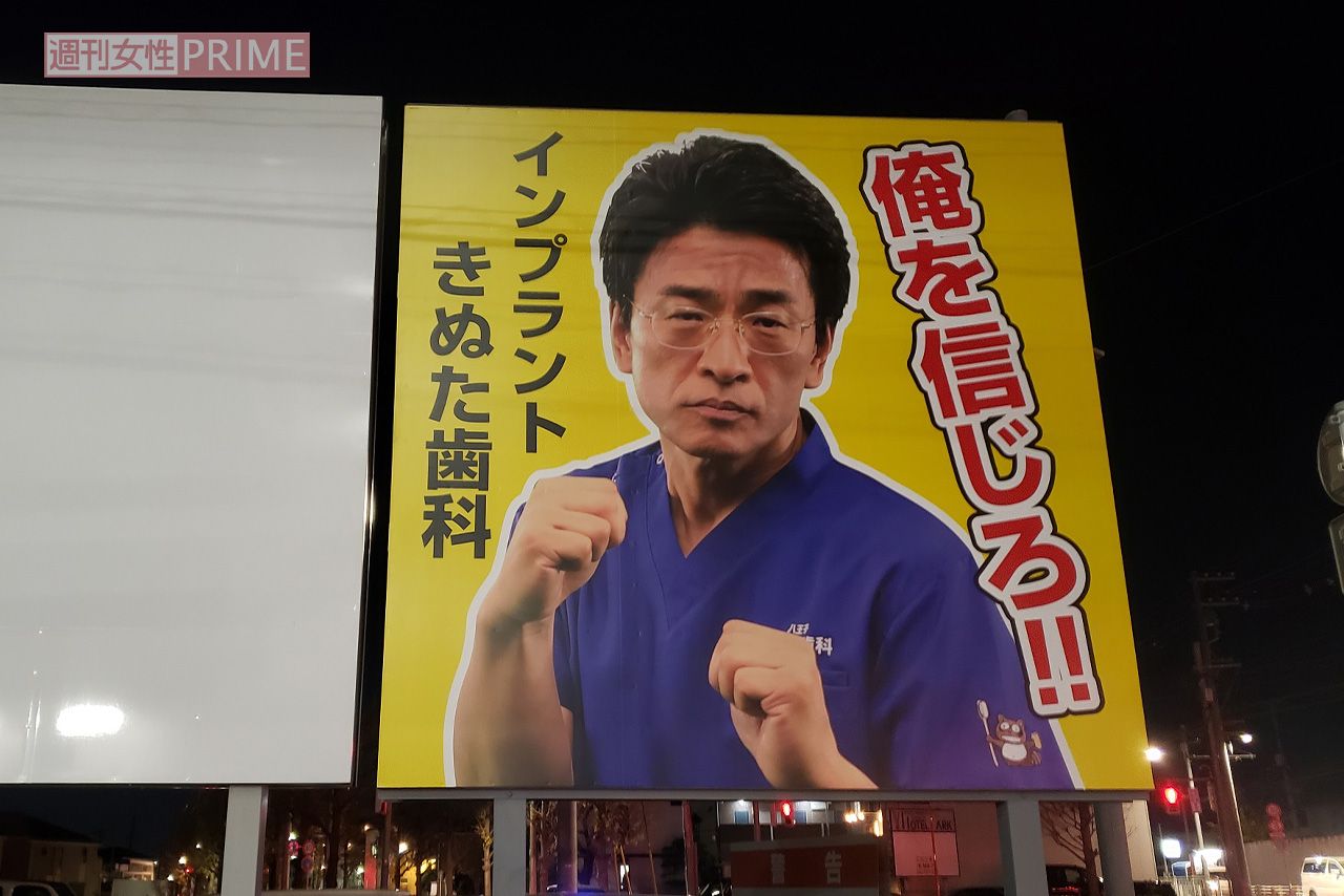 『きぬた歯科』看板マニアが260箇所から選ぶ「オススメ看板3選」その3「立川市北西部、玉川上水にかかる橋のたもとにあります。かつては違ったデザインの看板でしたが、太陽にさらされ色あせてしまい、昨年リニューアルを実行しました。掲げられたポーズは、格闘技イベント『RIZIN』でのキャンペーンに伴い撮影されたものですが、Twitterで“これを看板に載せたら？”という声が上がり実現しました。これと同じデザインの看板は、他にも8か所見られます」（『看板研究家』D.J.マメ氏）