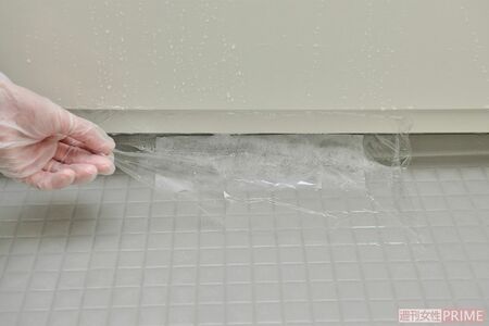 カビ除去成分が入った洗剤の上にキッチンペーパーをかぶせ、さらにその上にラップをかけることで洗剤をカビに密着させる。20～30分後に洗い流せば、頑固なカビも落ちやすい　撮影／山田智絵