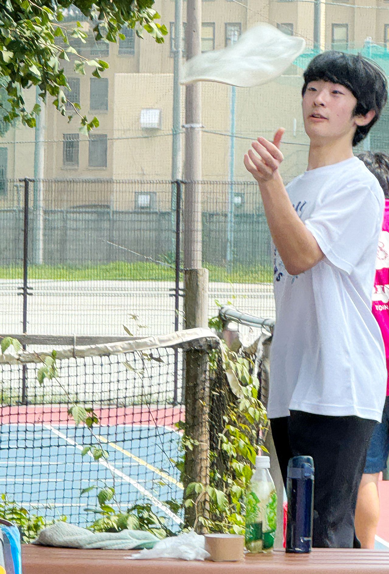 筑波大学附属高校の文化祭で、ご学友とピザ生地のようなものをくるくると回す悠仁さま（来場者提供）