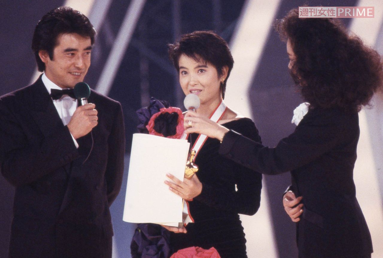 1987年の『全日本歌謡音楽祭』にて受賞の喜びを語る荻野目洋子。大判の赤い花が目立つ衣装も似合う