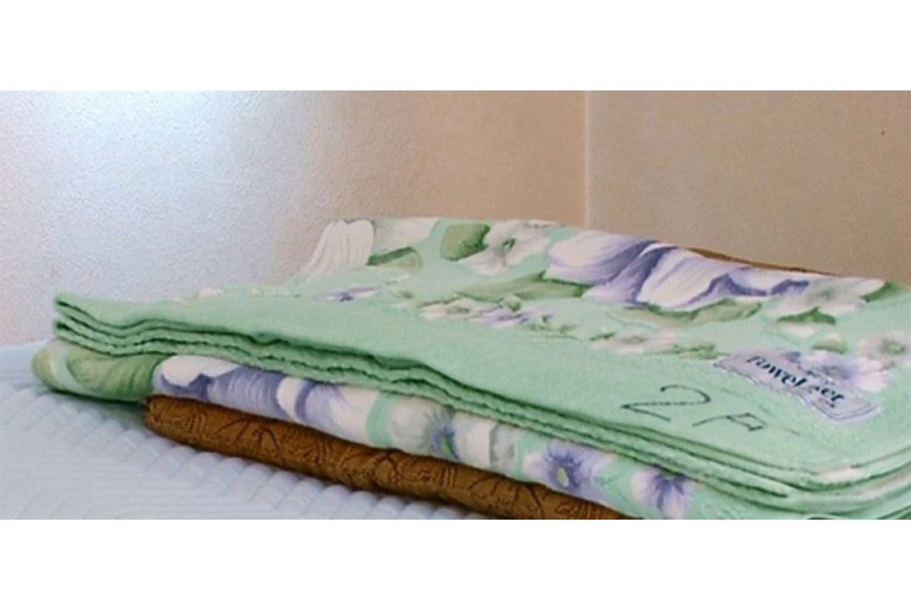 玄関マット枕の作り方（2）その上にタオルケットを折って重ねる。タオルケットの畳み具合を調整して自分の体格に合った高さにする（写真提供／16号整形外科）