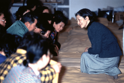 阪神・淡路大震災の避難所で膝をついて被災者を励まされた（'95年1月）