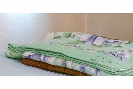 玄関マット枕の作り方（2）その上にタオルケットを折って重ねる。タオルケットの畳み具合を調整して自分の体格に合った高さにする（写真提供／16号整形外科）