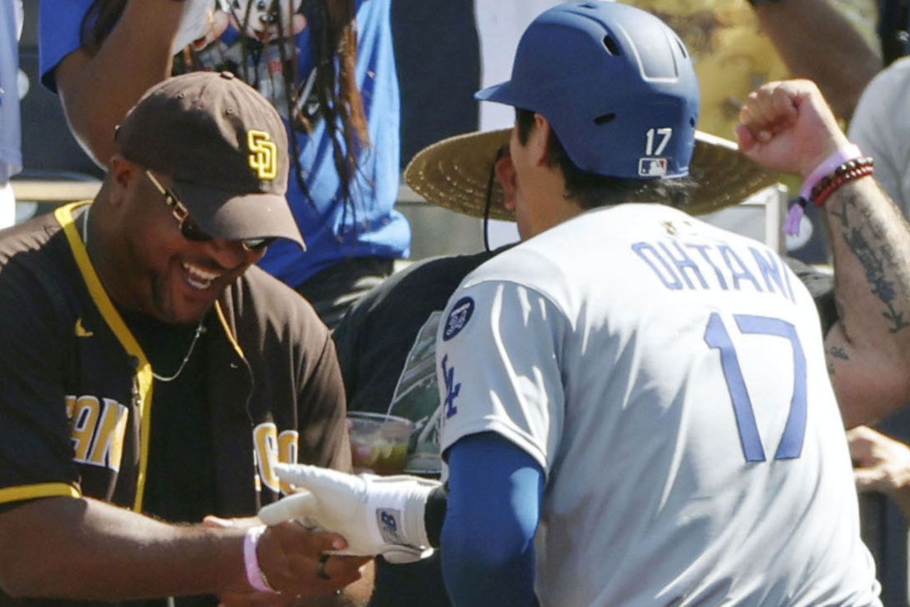 2025年8月25日、ヤジを飛ばしていたパドレスファンの男性とハイタッチする大谷翔平／共同通信