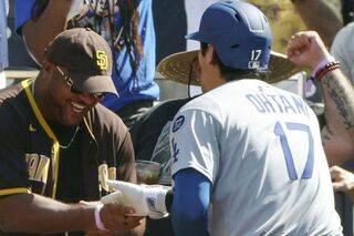 2025年8月25日、ヤジを飛ばしていたパドレスファンの男性とハイタッチする大谷翔平／共同通信