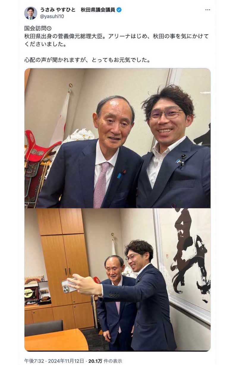 秋田県議会議員の宇佐見康人氏が2ショットを投稿した菅義偉氏。猫背気味の立ち姿勢や上手く笑顔の作れていない硬直した表情、どこを見ているのかわからない視線など、“元気”とはとても言い難いショット（宇佐美氏のXより）