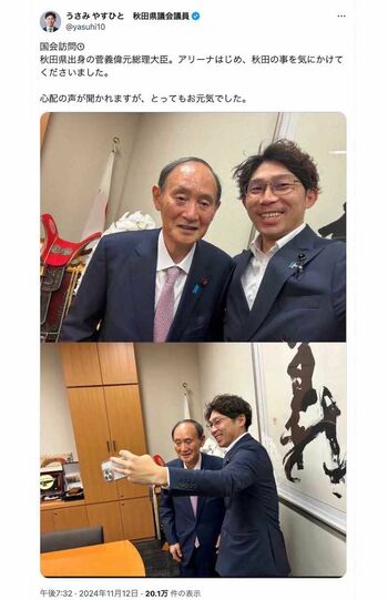 秋田県議会議員の宇佐見康人氏が2ショットを投稿した菅義偉氏。猫背気味の立ち姿勢や上手く笑顔の作れていない硬直した表情、どこを見ているのかわからない視線など、“元気”とはとても言い難いショット（宇佐美氏のXより）