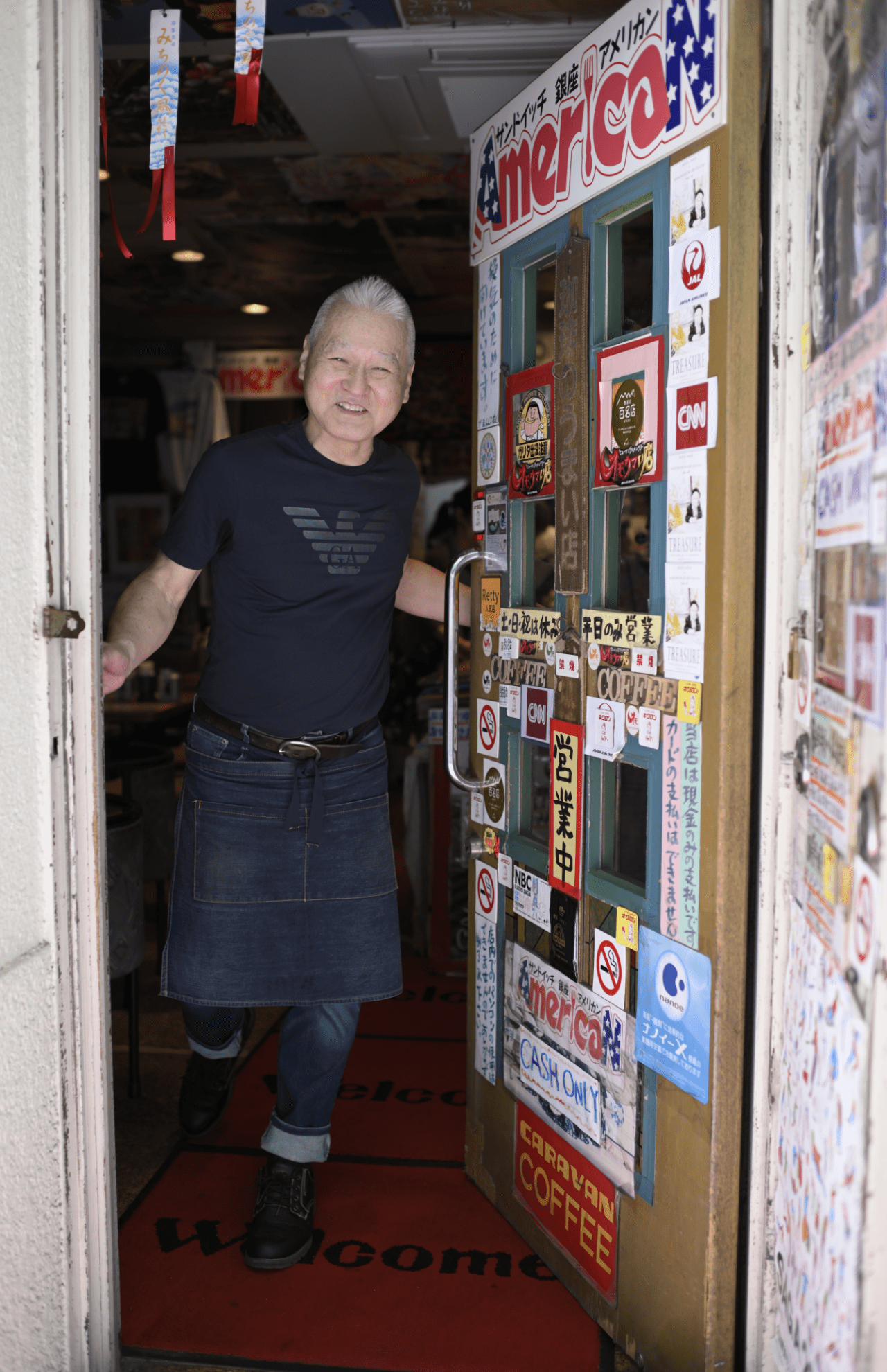 Tシャツにエプロン、ジーンズ姿のオシャレな原口さん。「この格好でバイク通勤してんだよ」