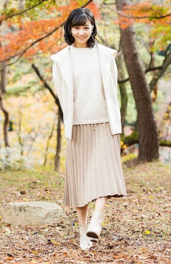 '22年12月、28歳のお誕生日に公開されたお姿。オフホワイトのフード付きショートコート＆ニットに合わせたのはミルクティー色のプリーツスカート。足元は淡いベージュのアンクル丈ブーツ。レアなカジュアル　写真提供／宮内庁