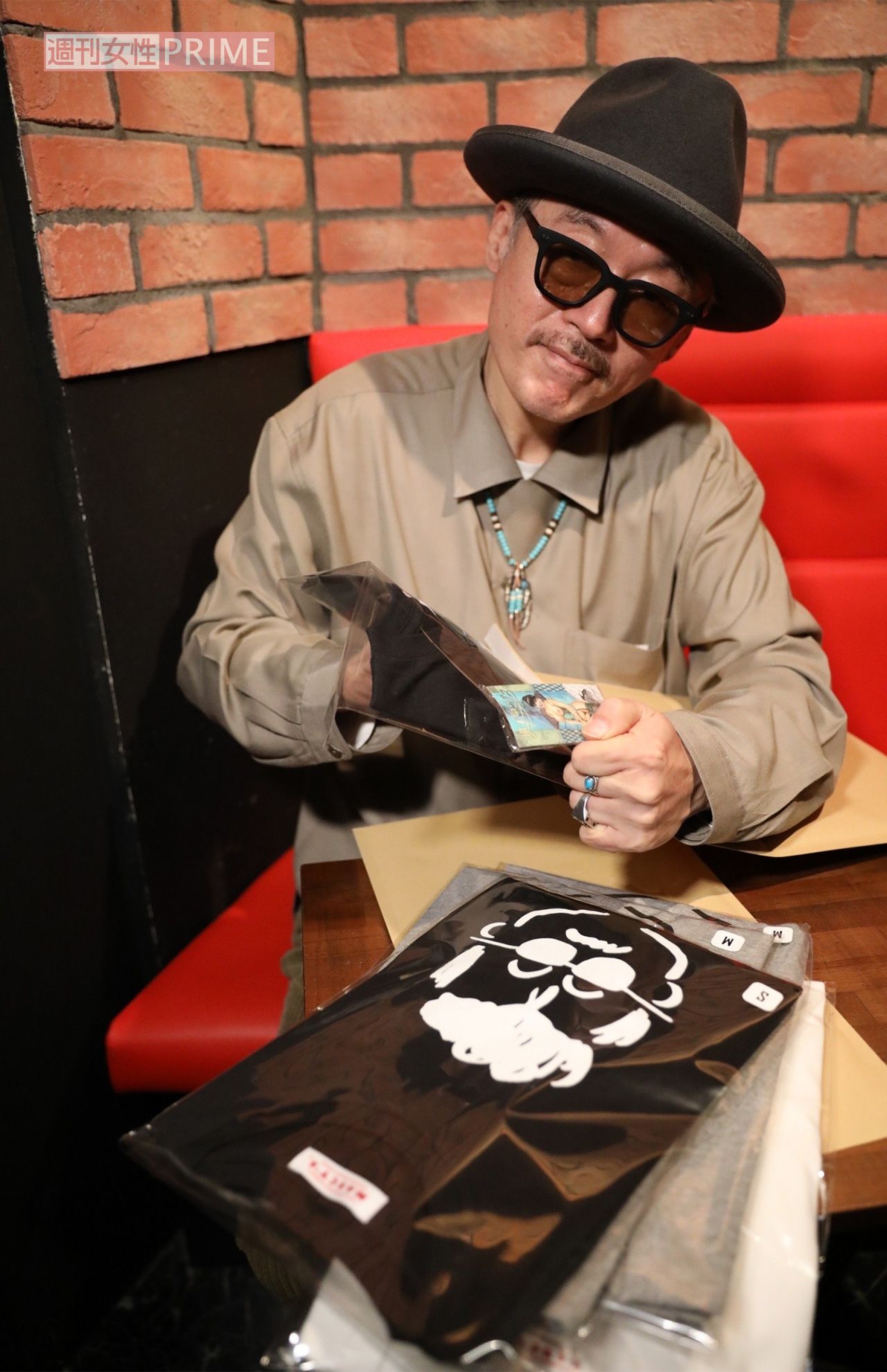 『マーシーズ』グッズを手にする田代まさし