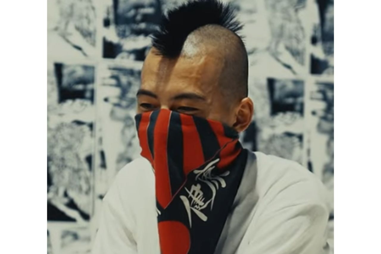 口元をスカーフで覆う吉岡容疑者（YouTubeより）