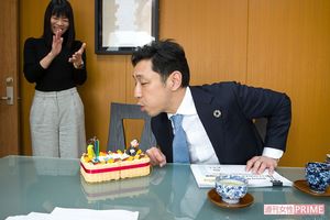 サプライズに喜び、ろうそくを吹き消す。社員のみんなもいい笑顔でお祝いする