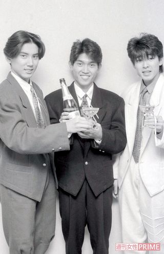 シャンパンを手に20歳のお祝いを。肩パッドとすそのカットが印象的な当時流行ったデザインのスーツに身を包んだ'85年の3人