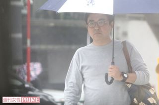 ミッキーマウスがプリントされた傘を片手に自宅から出てきた三平