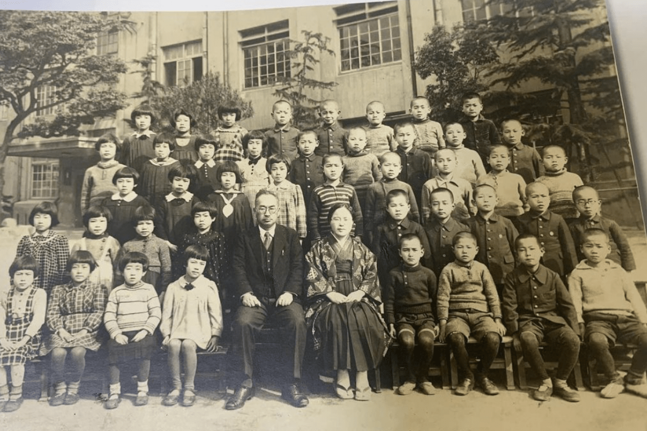 小学生のころの集合写真。前から2列目の右端でメガネをかけているのがのちの人気喜劇役者だ
