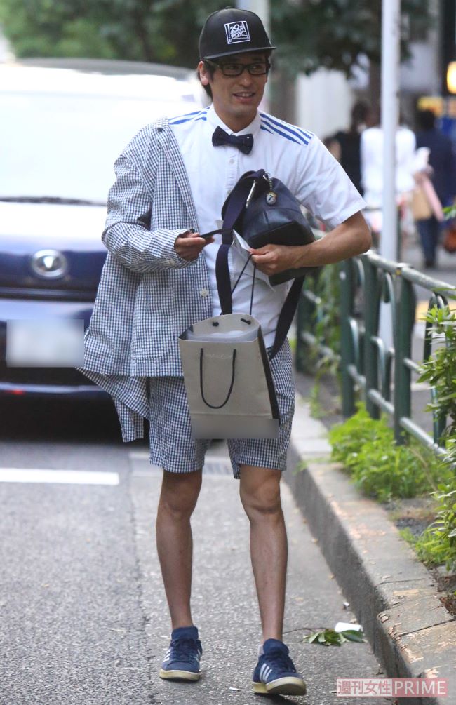 蝶ネクタイにチェックのセットアップを着た、独特なファッションセンスの佐藤隆太