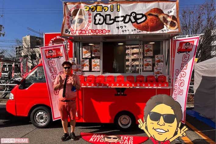 トレードマークの衣装と同じ赤い車に自身のイラストの看板も掲示して全国を巡っている8.6秒バズーカーのはまやねん