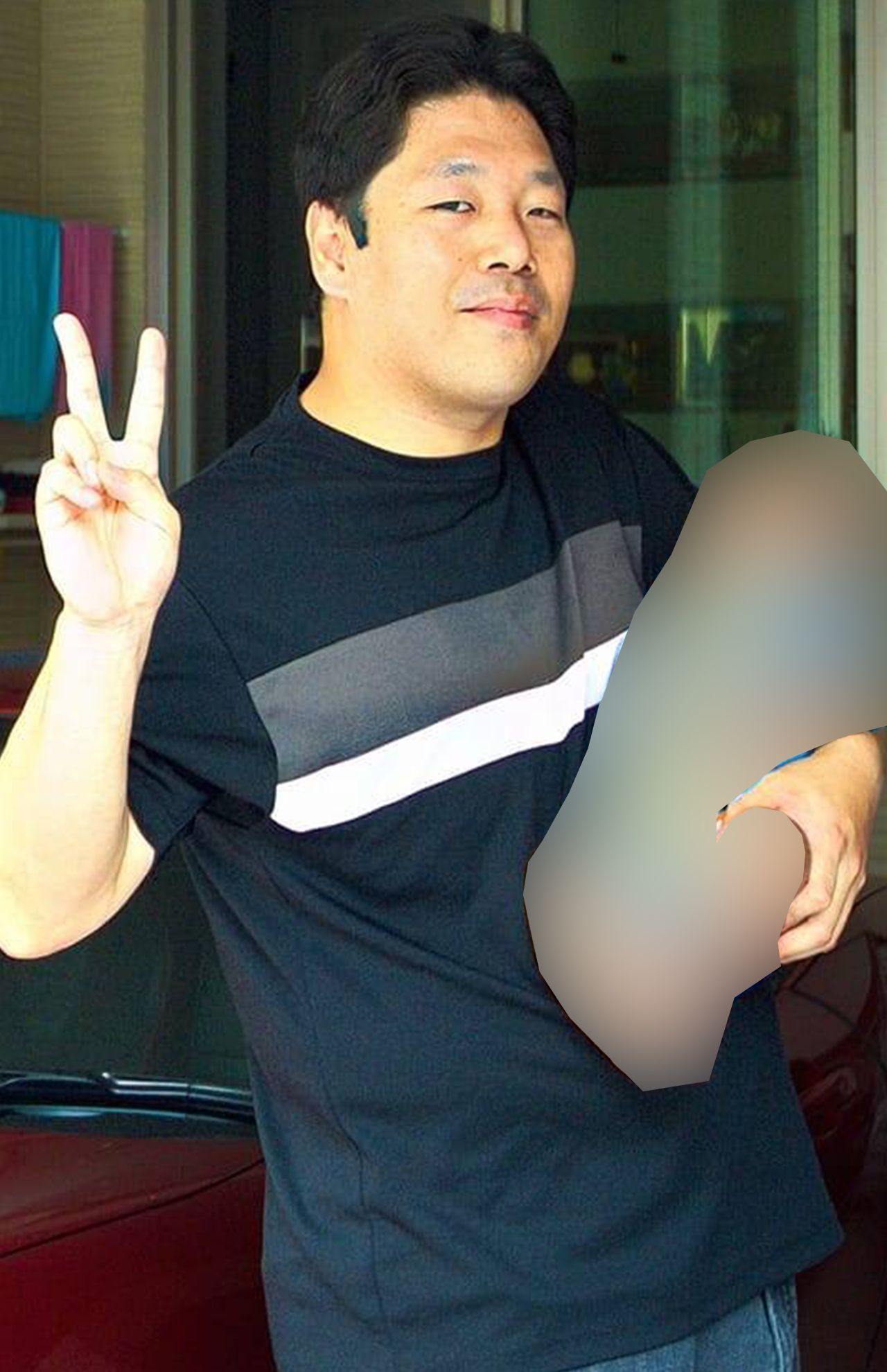 子どもを片手で抱っこし、右手でピースする西岡容疑者（本人のフェイスブックより、一部加工）